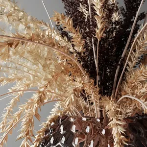 Bouquet of dried flowers in a glass vase on a tray